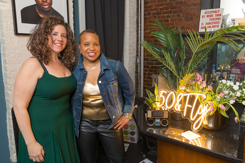 The two honorees posed together beside the neon sign at the start of the evening