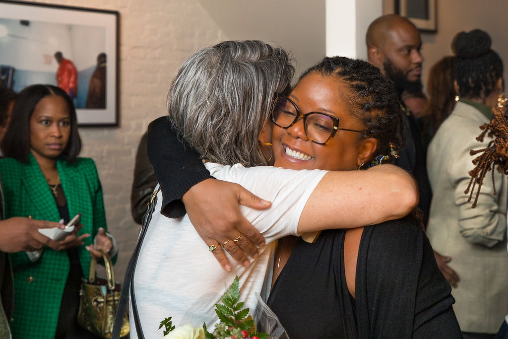 A warm embrace between friends — genuine emotion at a milestone celebration