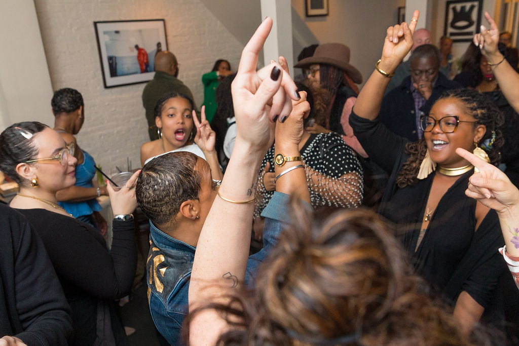 Hands raised on the dance floor — the room at full energy