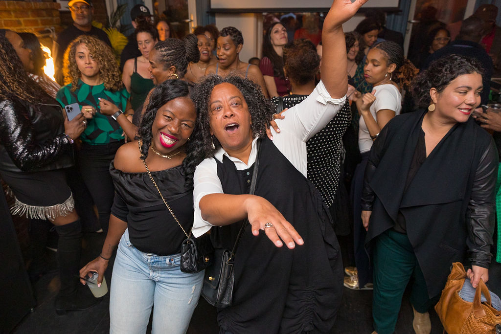 Pure joy on the dance floor — two guests laughing and dancing