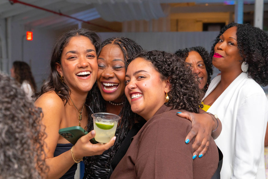 Three young women tight together, laughing