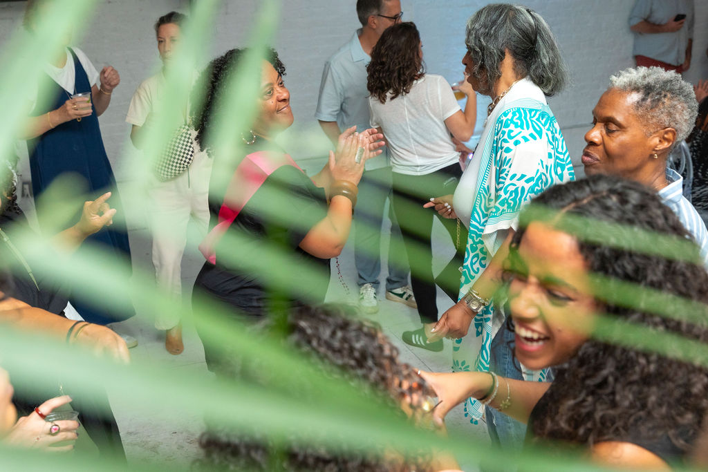 Three generations in the same room, viewed through foliage