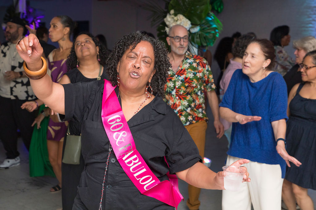 The 60-year-old honoree dancing — arm raised, eyes closed, the crowd around her