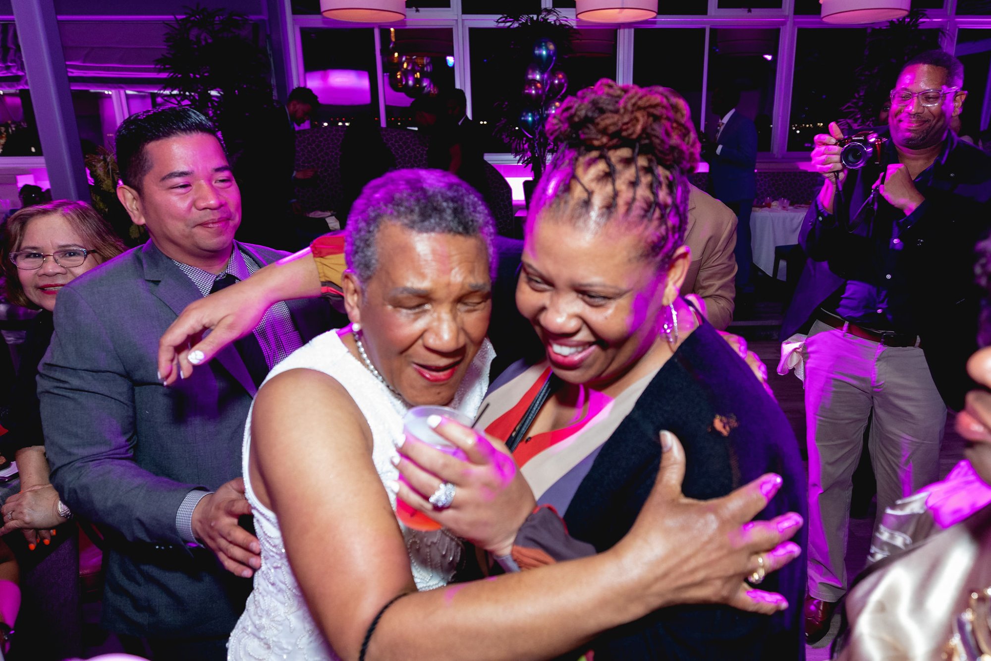 The honoree and a guest in a close warm embrace on the dance floor