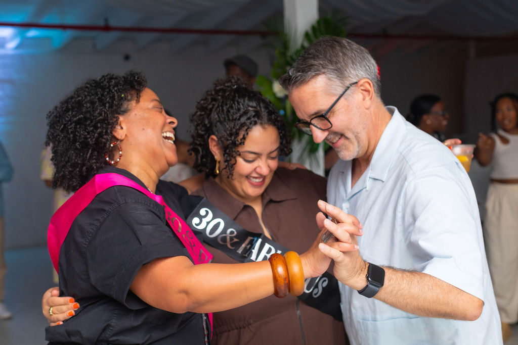 The 60th and 30th laughing together with a guest