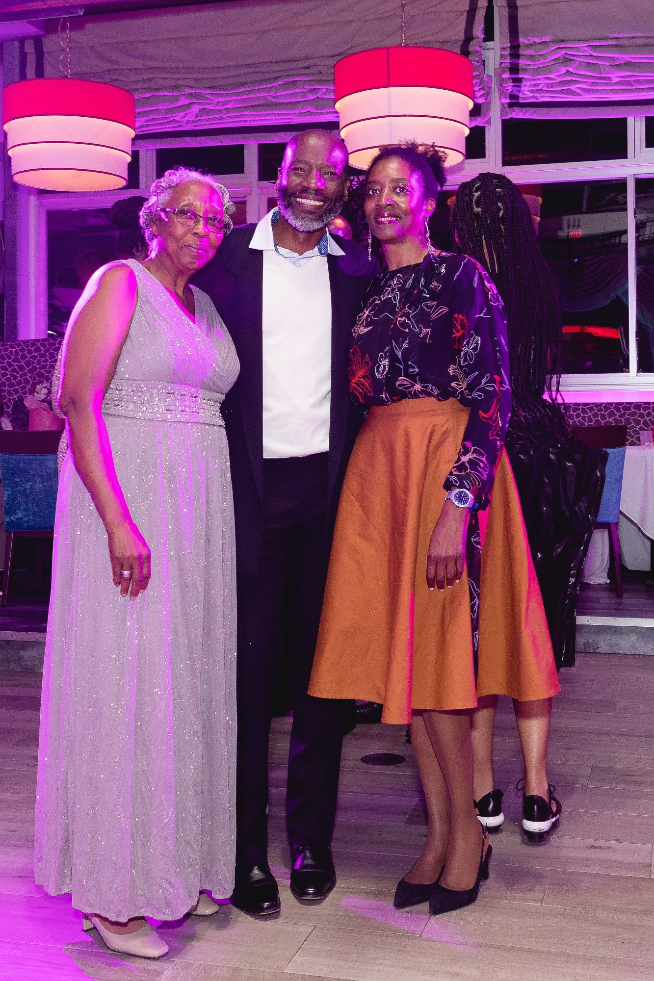 Honoree dancing with guest — back to camera, intimate moment, crowd in background