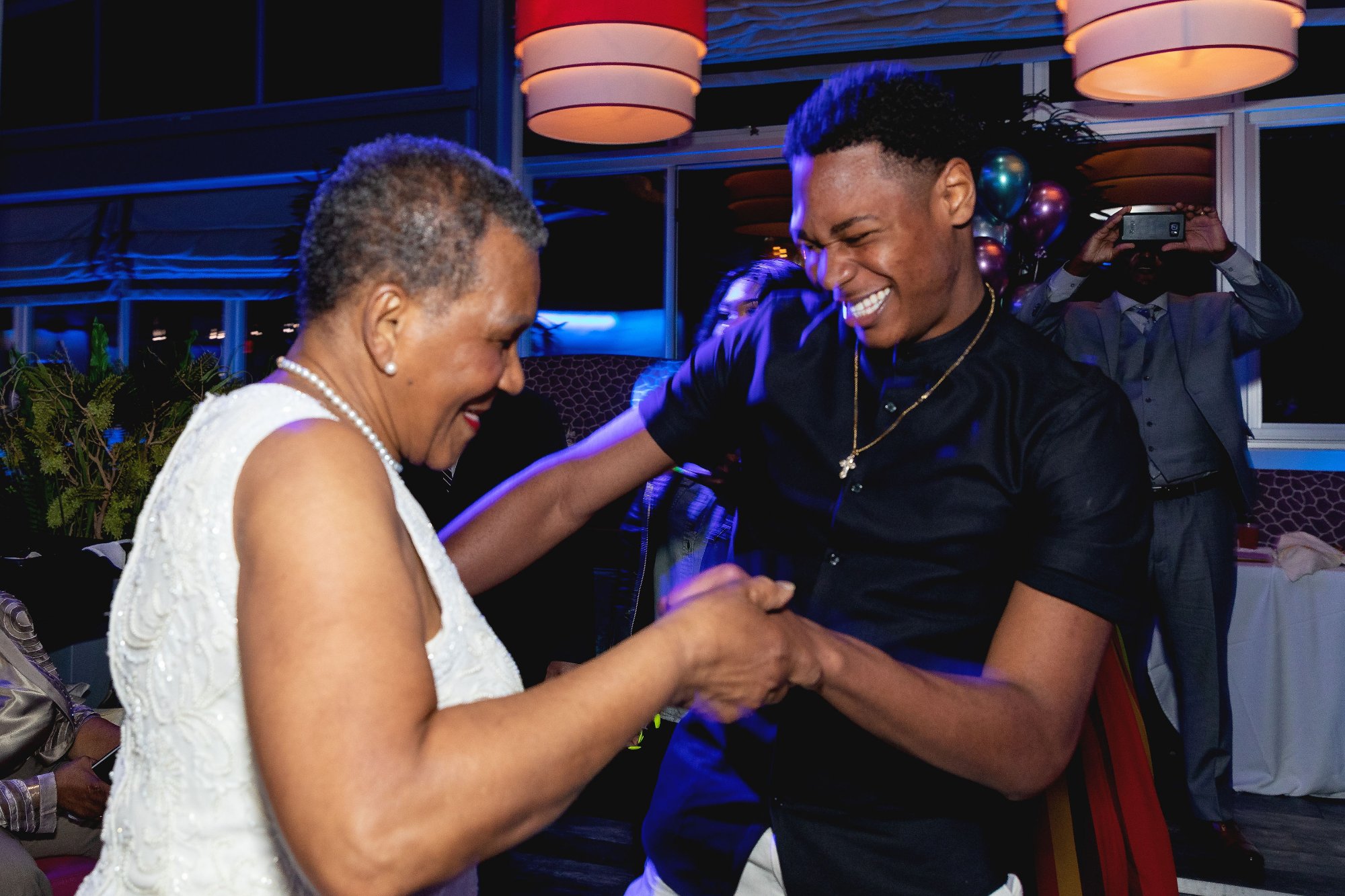 Honoree laughing in the crowd — surrounded, candid, fully in the moment