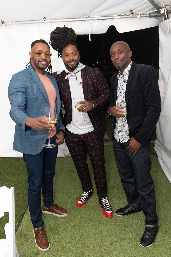 Three members of the group toasting with wine glasses