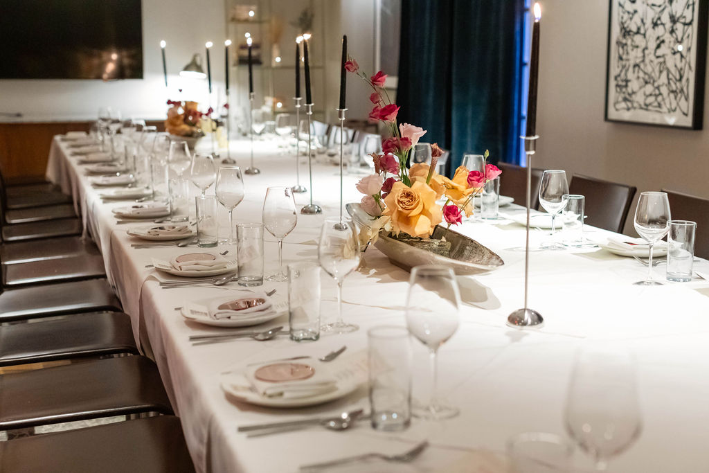 Table set with flowers and tall black candles
