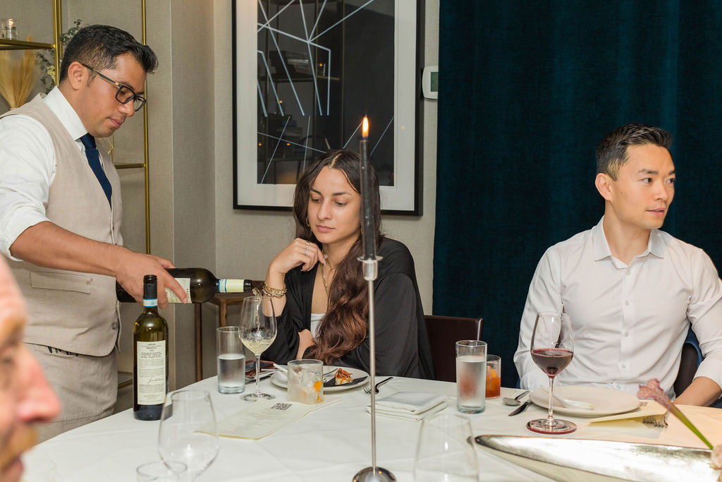 Sommelier pouring white wine by candlelight