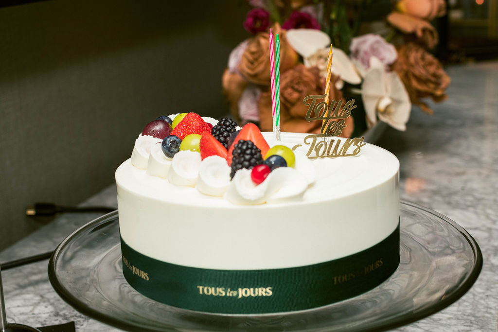 Tous les Jours cake with berries and candles