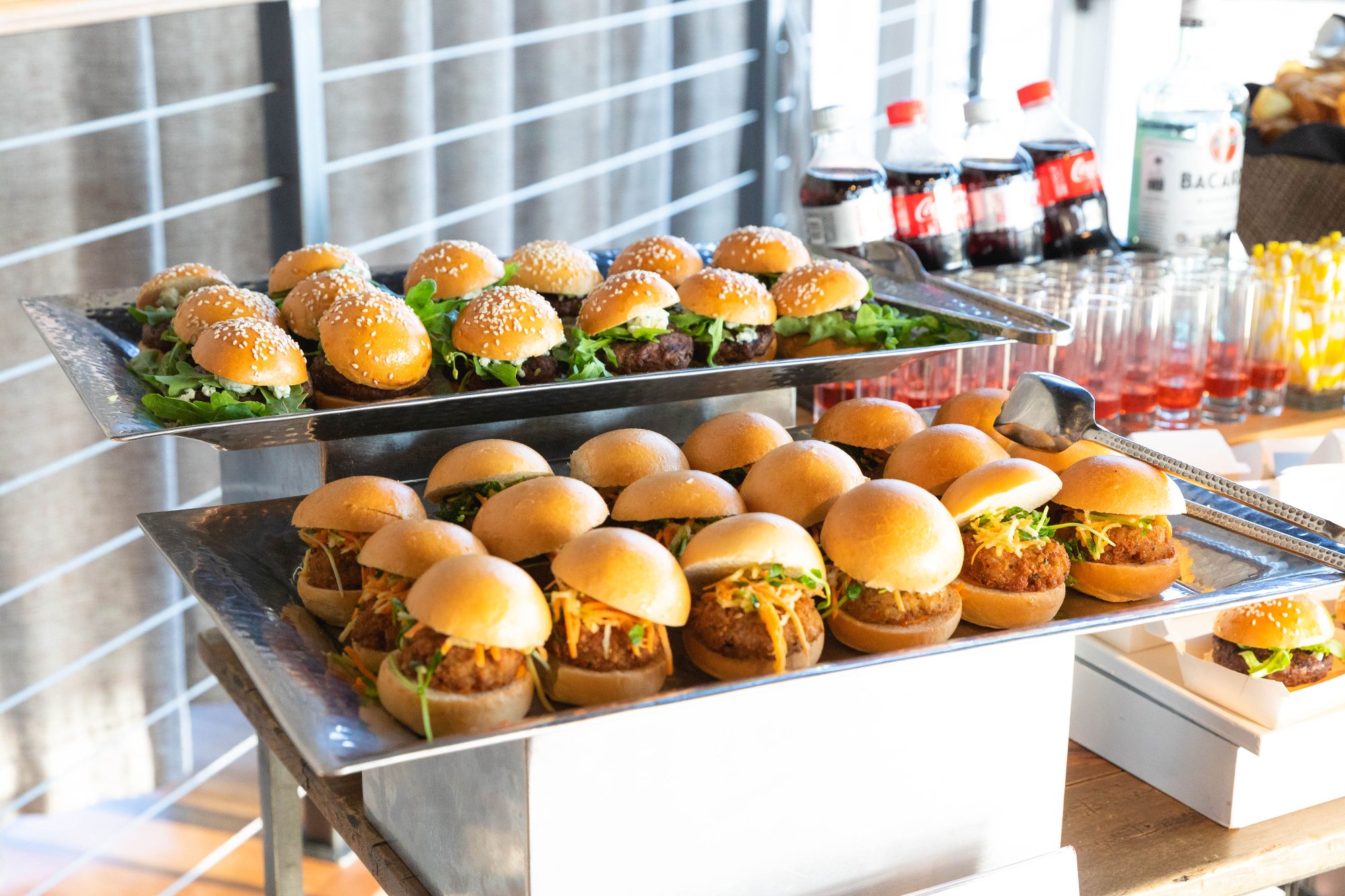 Guests mingling in the gala space — pendant lights above, natural light from windows