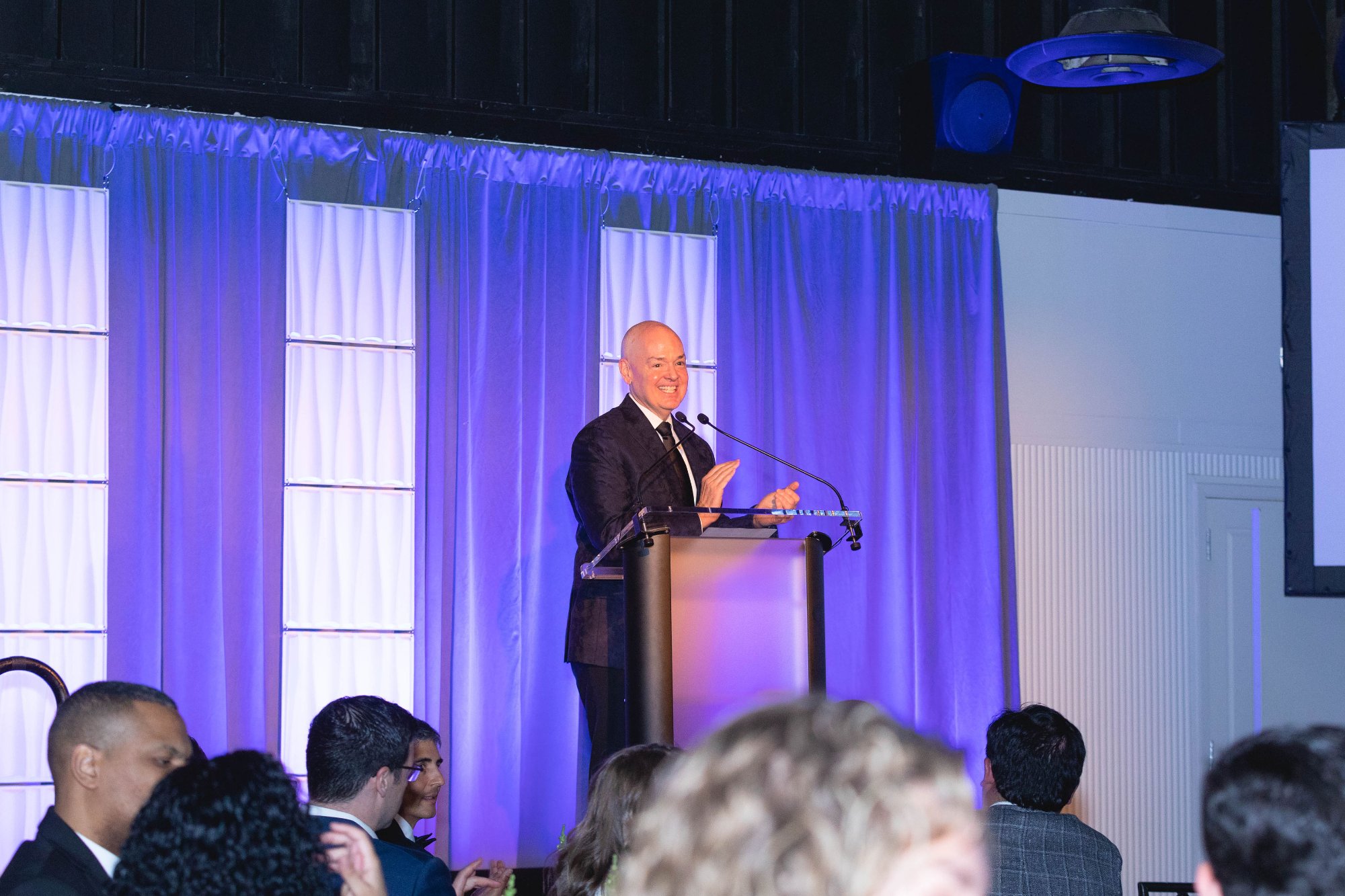 Guests at cocktail hour — industrial space, warm pendant lights