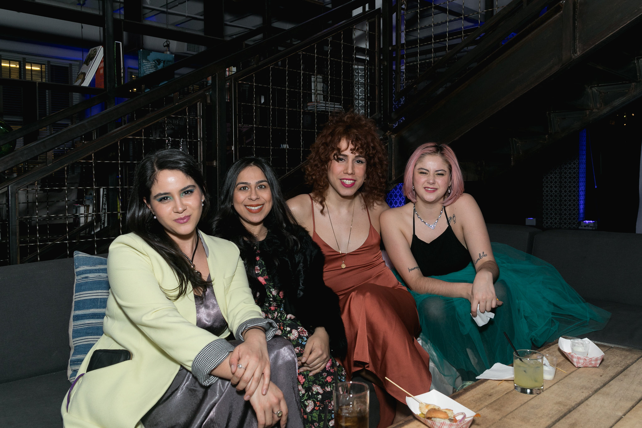 Group of four on the lounge sofa — still in conversation, the party around them