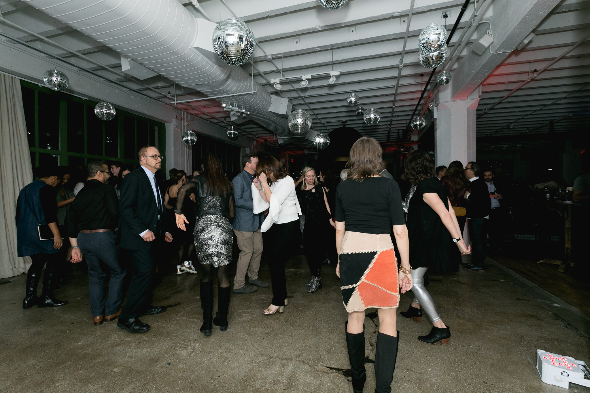 Dance floor earlier in the evening — disco balls lit, crowd building, motion beginning