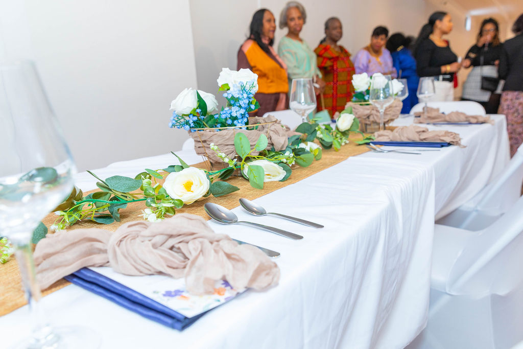 The long table in full — florals, place settings, guests arriving in background