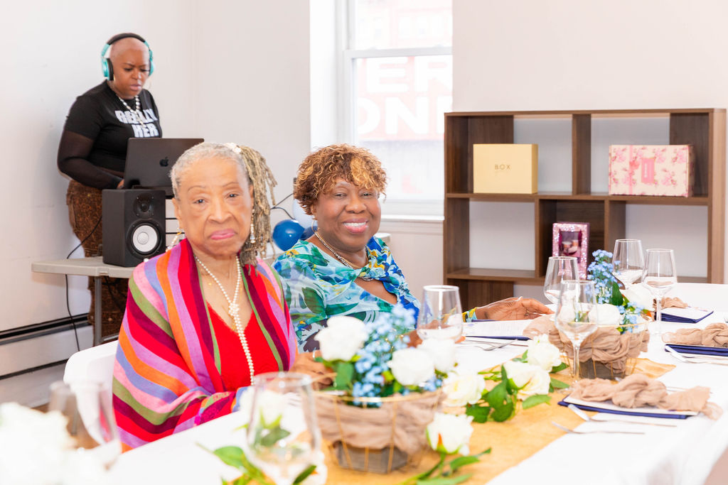 Two guests at the table — grandmother in striped shawl and pearls, daughter beside her