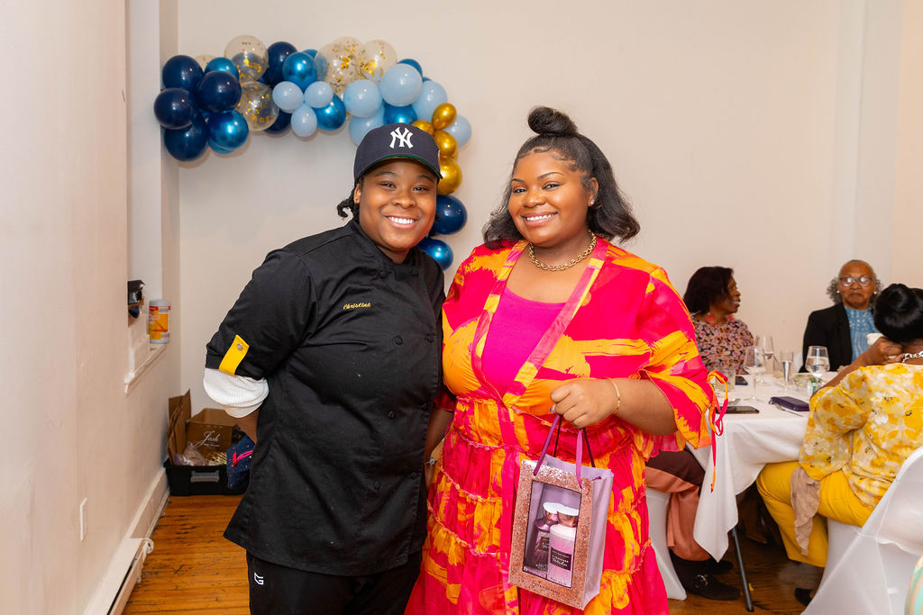 Two OSC team members — chef and colleague smiling together after service ends